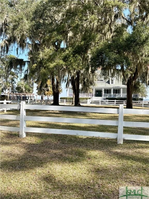 view of community with fence and a lawn