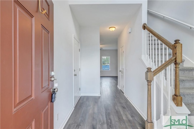 foyer with stairway, dark wood finished floors, and baseboards