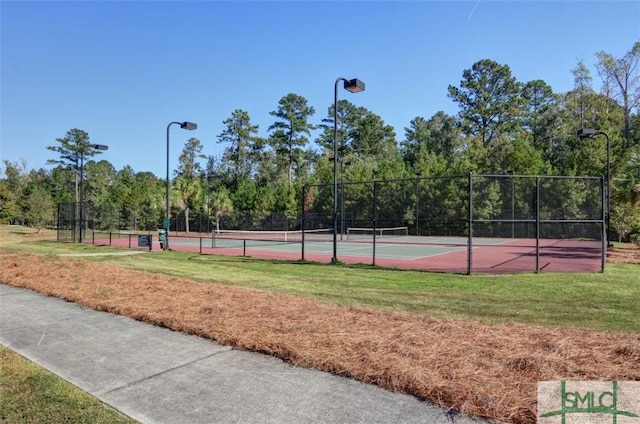 view of sport court featuring fence and a yard