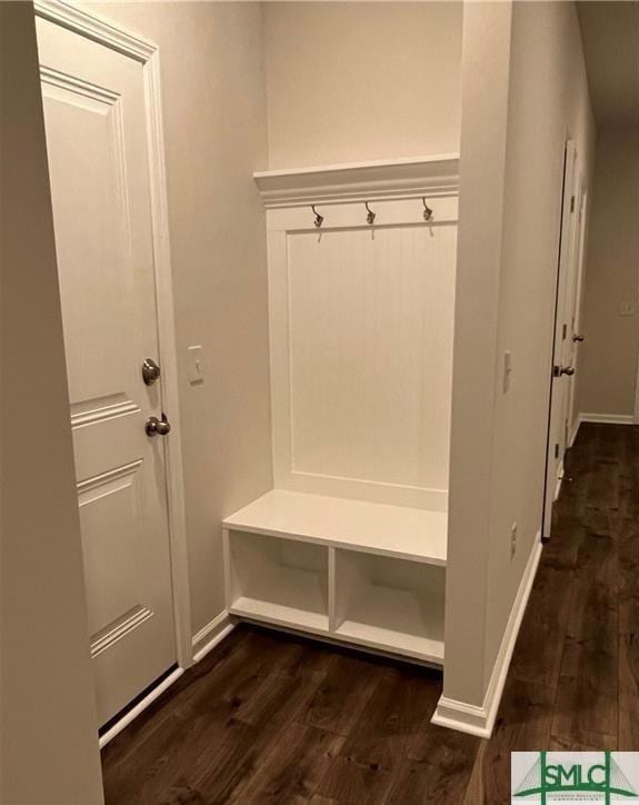 mudroom featuring dark wood-style flooring and baseboards