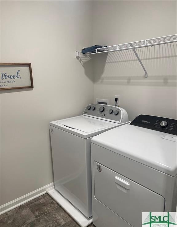 laundry room with laundry area, baseboards, and washer and clothes dryer