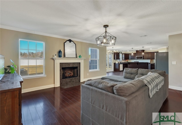 469 Nashview Trl, Allenhurst, GA 31301 - living area with a chandelier, dark wood-style flooring, a fireplace, baseboards, and crown molding