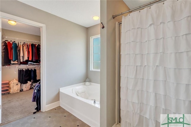 469 Nashview Trl, Allenhurst, GA 31301 - bathroom featuring walk in shower, baseboards, a walk in closet, and a bath