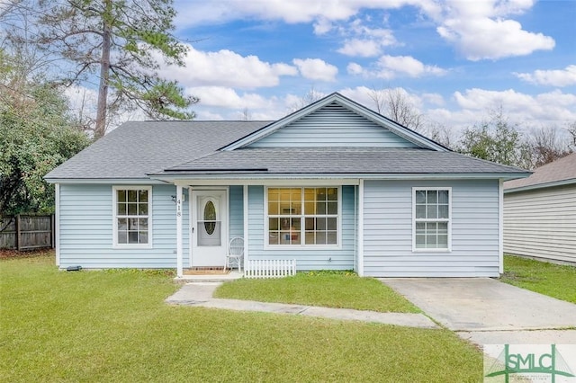 single story home featuring a front yard, roof with shingles, and fence