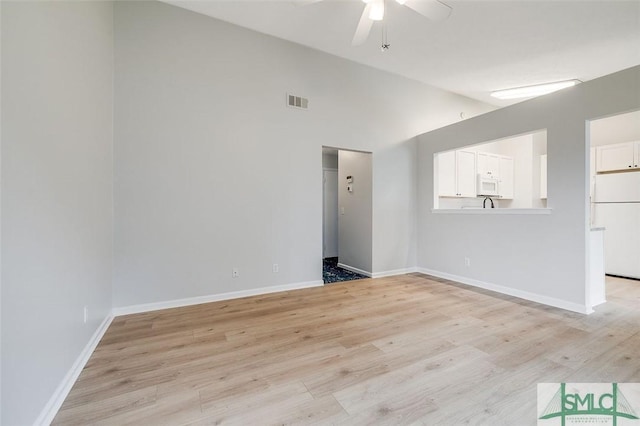 unfurnished living room with visible vents, baseboards, a ceiling fan, lofted ceiling, and light wood-type flooring