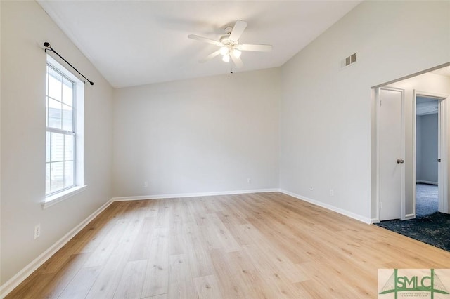 unfurnished room with light wood-type flooring, visible vents, and baseboards