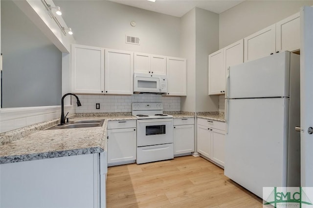 kitchen featuring light countertops, white appliances, white cabinetry, and a sink