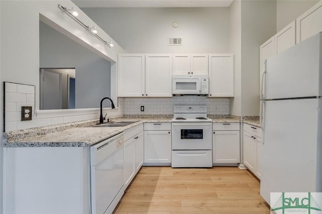 kitchen with visible vents, light wood-style floors, white cabinetry, a sink, and white appliances