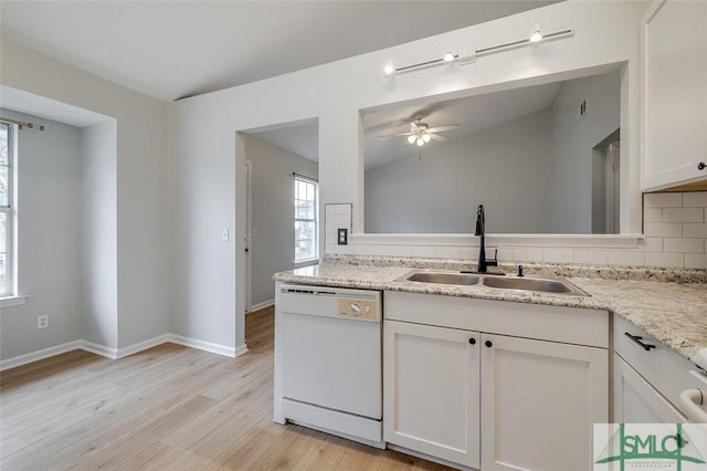 kitchen featuring white cabinets, light wood-style flooring, a sink, white dishwasher, and backsplash