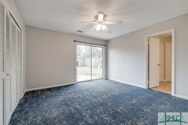 unfurnished bedroom featuring visible vents, light carpet, a textured ceiling, access to outside, and baseboards