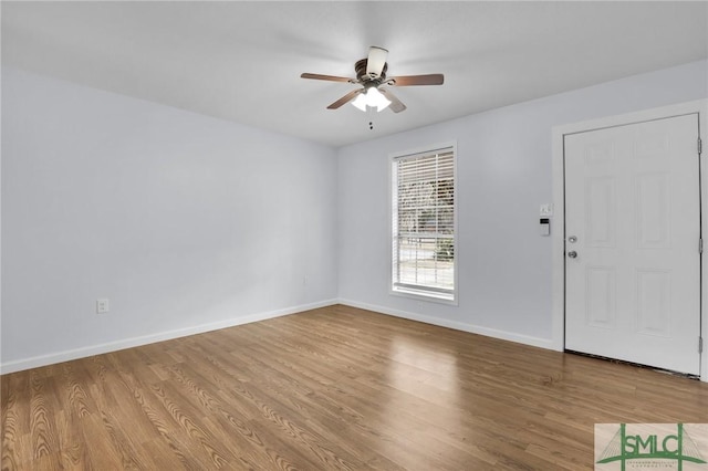 unfurnished room with light wood-style floors, baseboards, and a ceiling fan