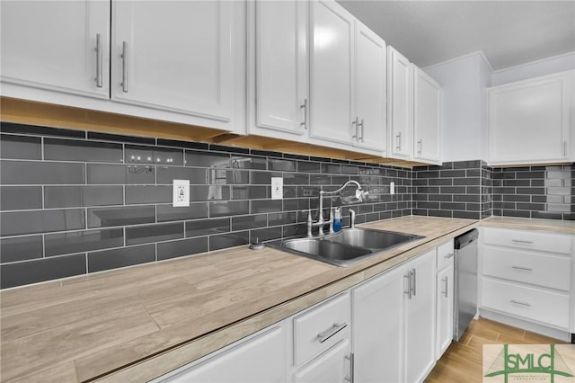 kitchen with dishwasher, white cabinetry, light countertops, and a sink