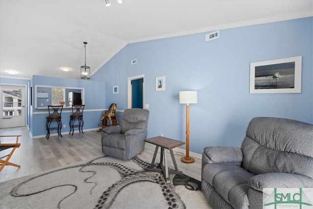 living room featuring lofted ceiling, light wood finished floors, visible vents, and baseboards