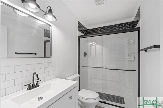 bathroom featuring vanity, a shower stall, visible vents, and decorative backsplash