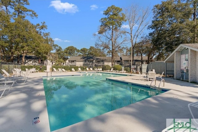 pool featuring a residential view, fence, and a patio