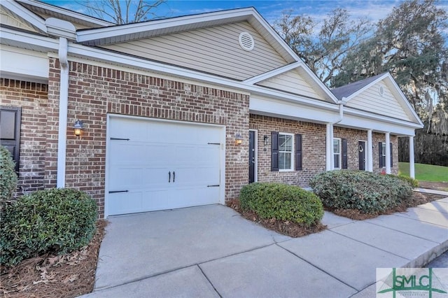 view of front of property with a garage, driveway, and brick siding