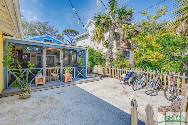 view of patio / terrace with a sunroom and fence