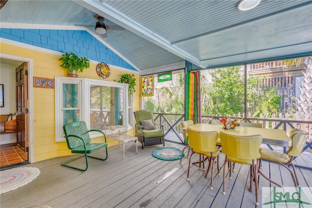 sunroom / solarium featuring vaulted ceiling with beams