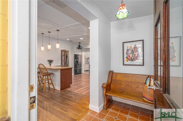 hall with dark wood-style floors, baseboards, and visible vents