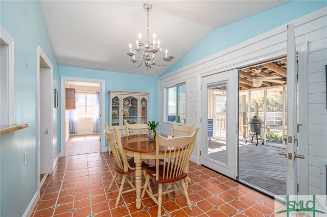 dining area featuring baseboards, vaulted ceiling, and a notable chandelier