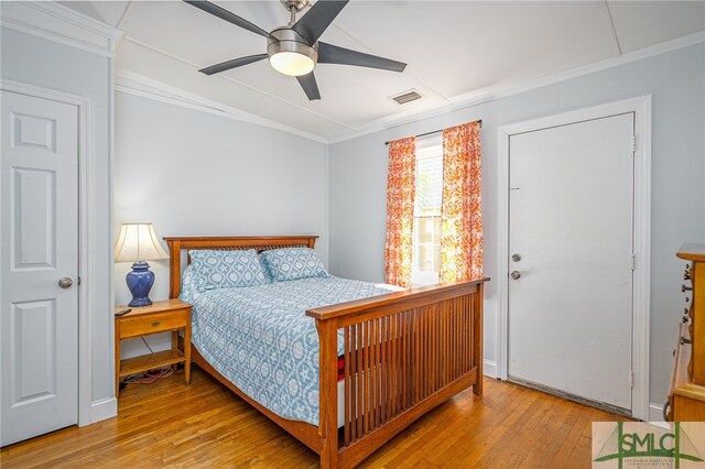 bedroom with light wood-type flooring, visible vents, ornamental molding, and ceiling fan