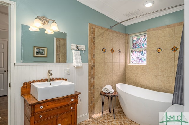 full bathroom with visible vents, a shower, vanity, crown molding, and a freestanding bath