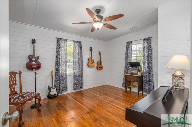 interior space featuring wood finished floors, visible vents, and a ceiling fan