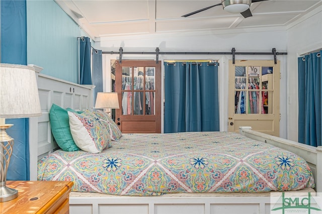 bedroom with ceiling fan and a barn door