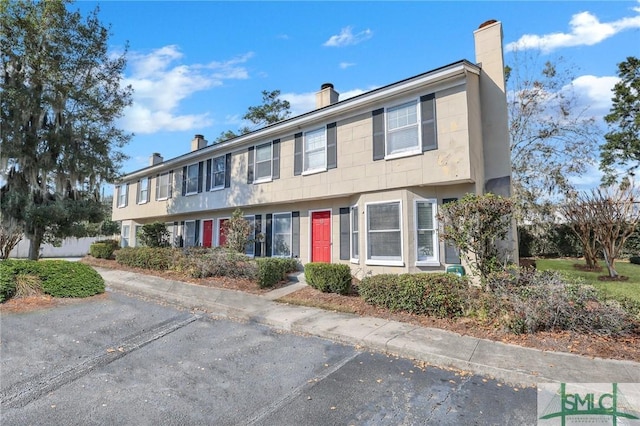 townhome / multi-family property featuring a chimney