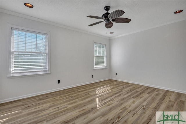 empty room featuring ornamental molding, light wood-style flooring, and baseboards