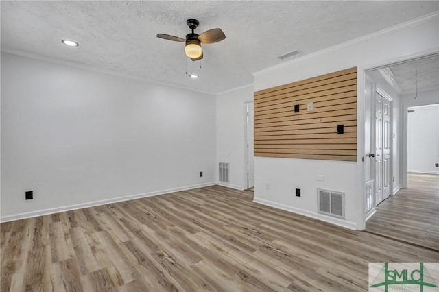 unfurnished living room with crown molding, visible vents, and attic access