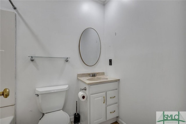 bathroom with toilet, baseboards, and vanity