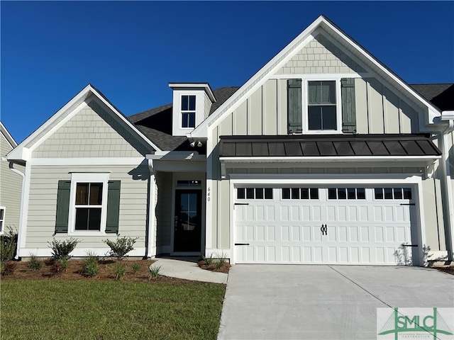 view of front of home with board and batten siding, a front yard, concrete driveway, and a garage