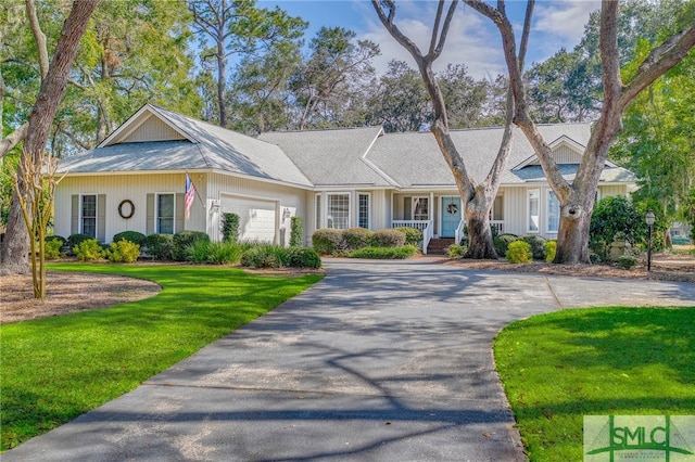 view of front of property featuring driveway, an attached garage, and a front yard