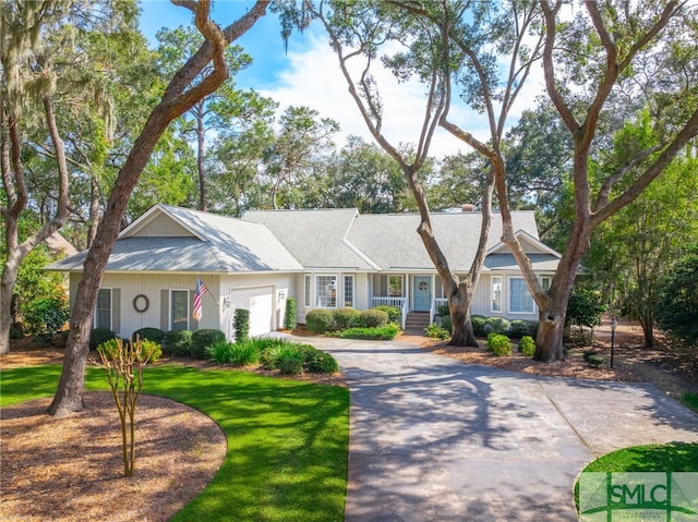 ranch-style house featuring driveway, an attached garage, and a front yard