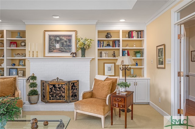 sitting room with built in shelves, a fireplace, crown molding, and baseboards