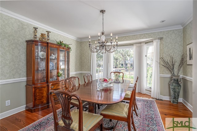 dining space with wallpapered walls, wood finished floors, and an inviting chandelier