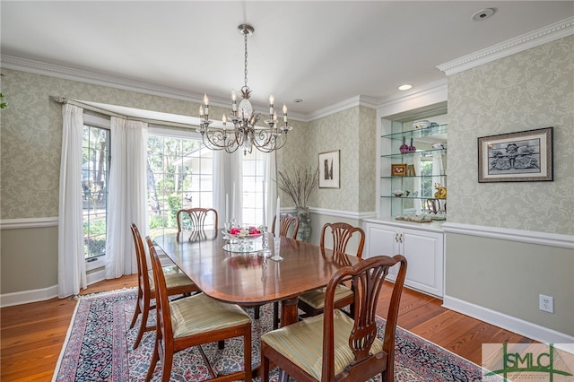 dining room with wallpapered walls, plenty of natural light, and wood finished floors