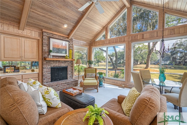 sunroom / solarium featuring vaulted ceiling with beams, a fireplace, wood ceiling, and a ceiling fan