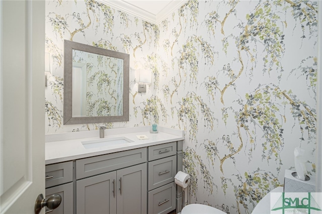 bathroom featuring crown molding, vanity, toilet, and wallpapered walls