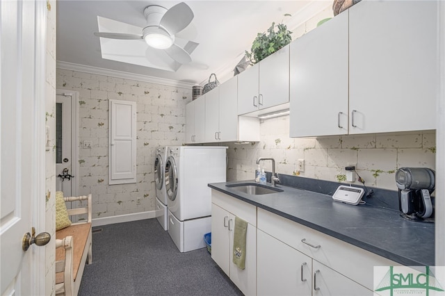 laundry area with cabinet space, a ceiling fan, crown molding, washer and dryer, and a sink