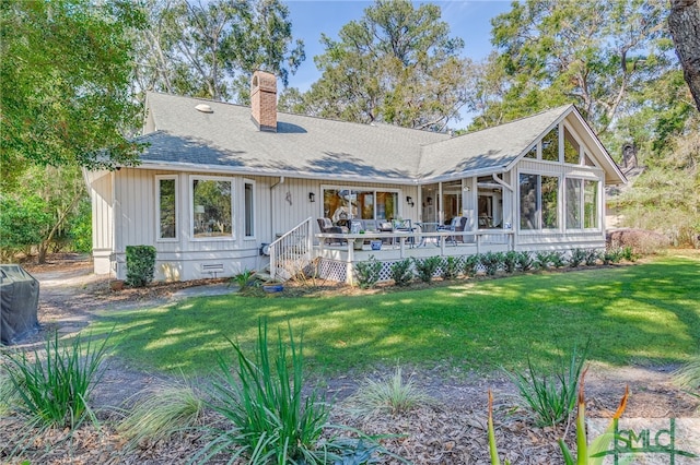 back of house with a shingled roof, a sunroom, a chimney, crawl space, and a yard