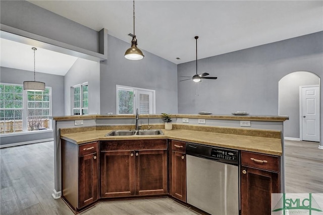 kitchen featuring a sink, light countertops, dishwasher, and decorative light fixtures