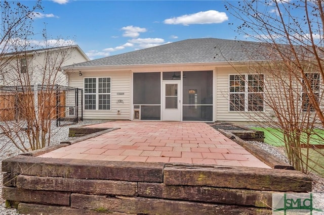 back of property with a patio area, fence, a sunroom, and roof with shingles