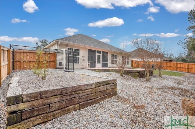 rear view of house with a fenced backyard and a patio