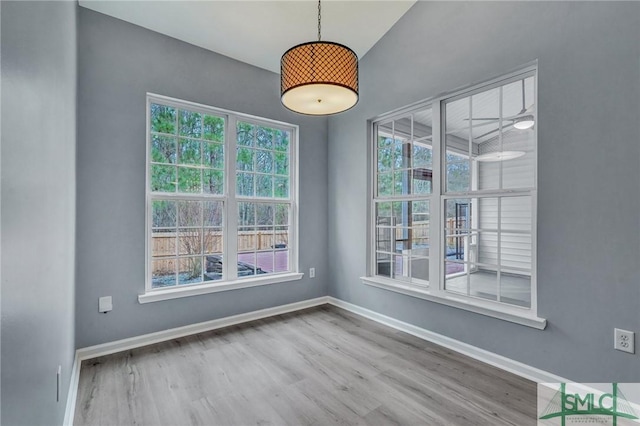 spare room featuring baseboards and wood finished floors