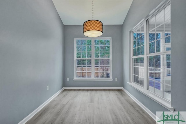 unfurnished dining area featuring light wood-style floors and baseboards