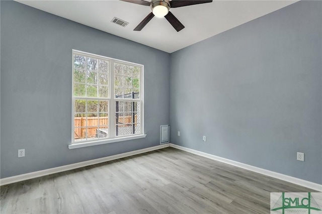 spare room with ceiling fan, light wood-style flooring, visible vents, and baseboards