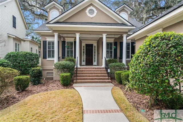 property entrance with metal roof, crawl space, a standing seam roof, covered porch, and stucco siding