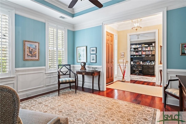 living area featuring ornamental molding, a wealth of natural light, visible vents, and wood finished floors